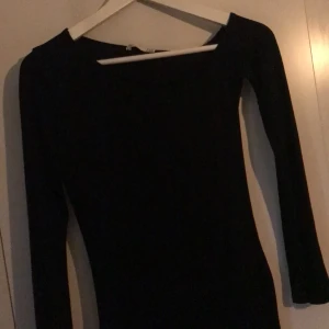 Klänning  - Svart klänning från nly trend. Långa armar varav ena armen täcker axeln och andra börjar längre ner. Tunt tyg så passar bättre på small än x-small så man fyller upp klänningen ordentligt .