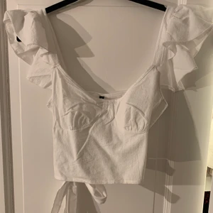 Topp - Oanvänd trendig blus/ topp i vitt linnematerial🌟 Toppen har fina volangaxlar och band i ryggen!