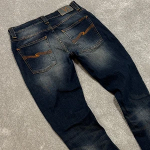 Nudie Grim Tim - Tja! Säljer dessa feta mörkblå/blå Nudie ”Grim Tim” jeansen med fet tvätt! Jeansen är i riktigt fint skick. Size 31/34 men passar 31/32. Skriv vid funderingar!