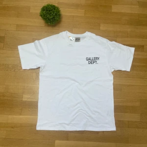 Vit t-shirt från Gallery Dept. - Säljer en vit t-shirt från Gallery Dept. med tryck på både fram- och baksidan. Perfekt för en oversized stil. Size L men passar bättre för XL. Aldrig använt (visste inte att tröjan skulle vara översized) pris kan diskuteras 