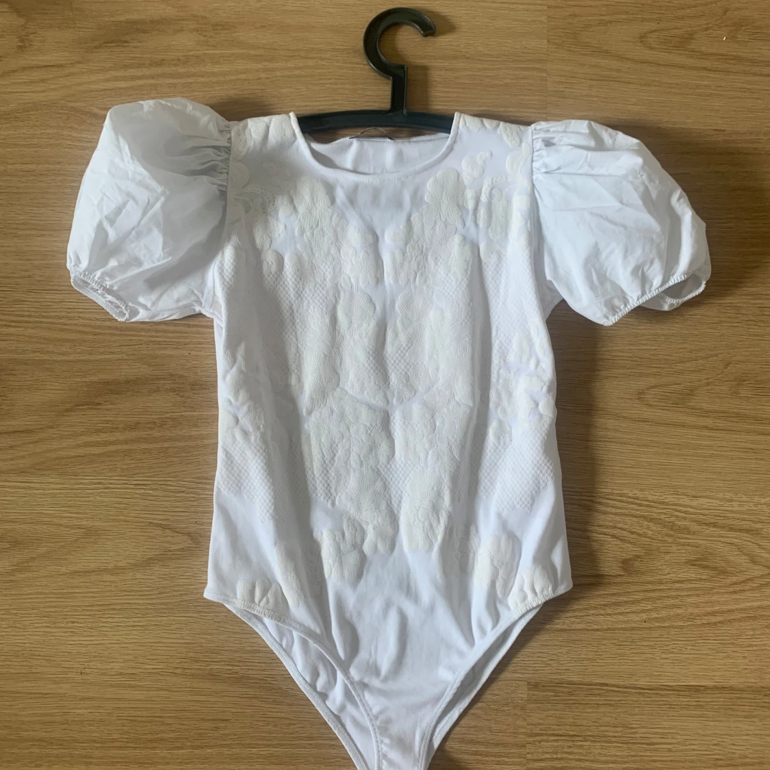 Vit body med puffärmar och spetsdetaljer