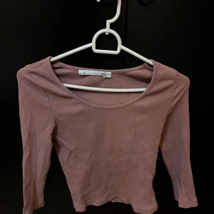 Rosa ribbad topp från 152 - Säljer en söt rosa ribbad topp från märket 152. Toppen har långa ärmar och en rund halsringning. Perfekt för en avslappnad stil. Passar bra till jeans eller kjol. 🌸
