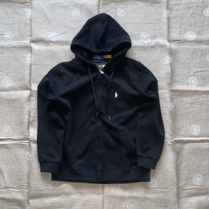 Ralph Lauren Zip-Up - Säljer en sprillans ny svart Ralph Lauren ”Zip-Up” hoodie. Aldrig använd, köpte den för en vecka sedan i en pop-up butik i Göteborg. Den ska vara XL men är mer L om jag ska vara ärlig.  Den passar fint och måtten stämmer. Passar fint med mörka jeans. 😄