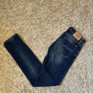Blå jeans från Nudie Jeans - Snygga blå jeans från Nudie jeans, med en slim passform Mycket bra skick, utan några märkvärda anmärkningar. Storlek 27/34 mått kan såklart skickas vid osäkerhet. En riktigt skön wash på dessa. Postas antigen samma dag som köp eller dagen därpå, sänker priset 50kr vid snabb och smidig affär 💯🙌