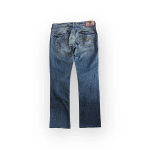 Replay jeans - Snygga blå jeans från Replay med blommigt broderi på bakfickorna. Jeansen har kortats ner och har lagningar på insidan som ej är märkbara. Storlek W30 passar M. Midja 42 innerben 78.
