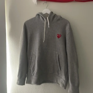 Grå hoodie från Comme des Garçons PLAY - Säljer min gråa hoodie för den här växt ur mig. Storlek M men är liten i storleken så den passar dig som är allt från ~ 170-180. Köpt ny i London på Dover street market för 2600kr. Inga deflekter eller så. Vill du ha mer bilder så är det bara att fråga, eller om du har andra frågor😄