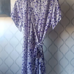 Blommig omlottklänning i lila och vit - Säljer en söt blommig omlottklänning i lila och vit. Klänningen har korta ärmar och ett knytband i midjan för en smickrande passform. Perfekt för varma dagar. Nästan aldrig använd, storlek är oklart. Pris kan diskuteras!!! 