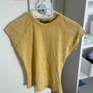Gul ribbad topp från Zara - Säljer en superfin gul tröja från Zara, aldrig använd och har prislappen kvar. Den är väldigt liten i storlek så skulle säga den passar en xs/s beroende på hur tajt man vill den ska sitta