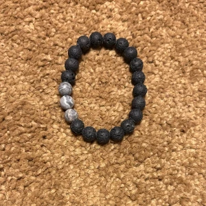 Svart och grått pärlarmband - Snyggt armband med svarta lavastenpärlor och tre grå marmorliknande pärlor. Perfekt för att ge en stilren touch till din outfit.