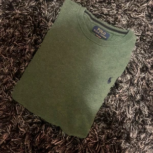 Grön tröja från Ralph Lauren - Säljer en stilren grön stickad sweater från Ralph lauren. Den passar fint för inte bara vinter dagar utan höst, vårdagar eller varför inte en kylig sommar kväll. Storleken är 14-16 men passar möjligtvis lite mindre. Denna tröja är extremt snyggt och i ett bra skick. Om du vill ha fler bilder eller har några frågor så tveka inte att skriva!