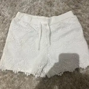 Säljer ett par vita shorts med vacker spetsdetalj och knytband i midjan. Perfekta för sommaren🤍Storlek 158 men skulle kunna passa xxs/xs då de har en elastisk midja🤍🤍