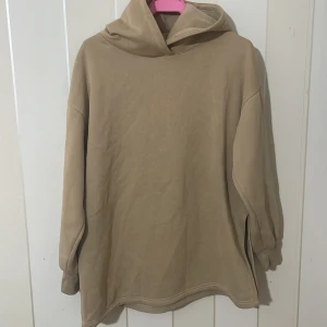 Beige hoodie - Säljer en beige hoodie med långa ärmar och en klassisk huva. Perfekt för en avslappnad stil. Passar bra till både jeans och mjukisbyxor.