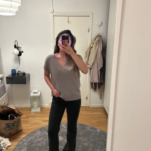 Beige grå tröja från Wera - Säljer en stilren beige blus från Wera med v-ringning och korta ärmar. Storlek S