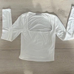 Vit långärmad topp från Sincerely Jules - Snygg vit långärmad topp från Sincerely Jules med en fyrkantig urringning. Perfekt för en stilren look. Tillverkad i ett mjukt och bekvämt material.🩷🩷