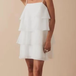 Vit axelbandslös klänning student klänning  - Säljer en söt vit axelbandslös klänning med volanger. Perfekt för sommarens alla tillfällen. Klänningen har en luftig passform och är gjord i ett lätt material.helt ny