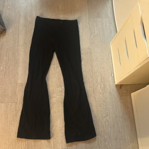 Svarta bootcut tights - Snygga svarta bootcut tights med en stilren design. Perfekta för en avslappnad men ändå trendig look. Byxorna har en bekväm passform och är ett mångsidigt tillskott till garderoben.
