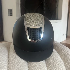 Ridhjälm - En bra och bekväm ridhjälm, den har några få repor och ett vitt märke på ena sidan. Annars bra skick.