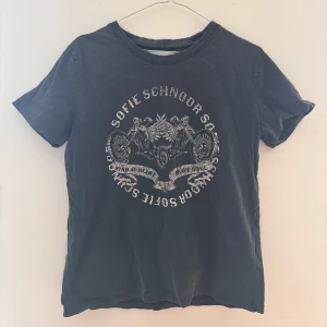 Svart t-shirt med tryck från Sofie Schnoor - Cool svart t-shirt från Sofie Schnoor med ett tryck  på framsidan. T-shirten har en rund hals och korta ärmar. I nyskick! 