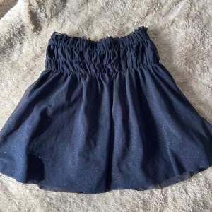 Mörkblå glittrig kjol från Zara - Säljer en söt mörkblå kjol från Zara med glittrande detaljer. Storlek 164 men sitter som en Xs/S🩷
