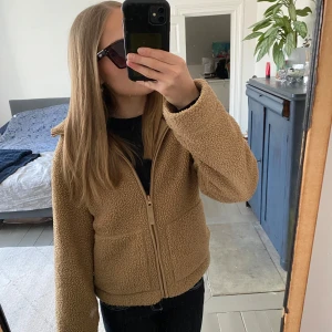 Brun teddyjacka från H&M - Mysig skitsnygg brun teddyjacka från H&M med dragkedja framtill. Jackan har långa ärmar och två praktiska fickor. Perfekt nu till våren!!💗💗