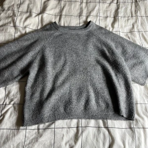 Grå stickad tröja från 157 - Säljer en mysig grå stickad tröja från 157. Tröjan har en enkel design med ribbstickade kanter och är perfekt för kyligare dagar. Passar bra till både jeans och kjol. Perfekt för en avslappnad stil. Ganska använd men inga fläckar eller andra utmärkelser. Väljer att säja då den är för stor.