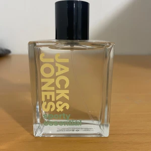 Jack & Jones Sporty Essential Eau de Toilette - Säljer en fräsch och energisk Eau de Toilette från Jack & Jones, Sporty Essential. Flaskan är stilren och rektangulär med en svart kork. Perfekt för den som gillar en sportig och uppfriskande doft. Hade passat om man ska gymma eller köra nån sport istället för och lukta illa då, använde bara den en gång och priset går att diskutera 