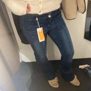 Mörkblå low waist bootcut jeans  - Helt oanvända!!!! Så dom är helt nyaaa!! Säljer ett par mörkblå jeans med bootcut-modell och markerade sömmar. Byxorna har stora fickor fram och klassisk jeansknapp ❤️❤️ Dom är från gina Young i strl 170 passar på mig som är ca 1,65 cm lång❤️ Jag har vanligtvis S på jeans🥰