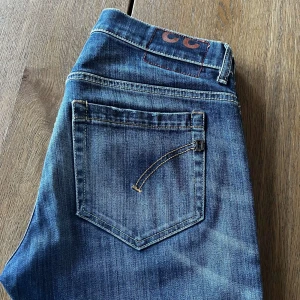 W31 L32 || Dondup George - Säljer ett par klassiska blå dondup George jeans  med snygga slitningar. Jeansen har fem fickor, dragkedja och knapp framtill samt kontrastsömmar. Perfekta för en avslappnad stil. Hör bara av dig vid någon fråga. Pris kan diskuteras.