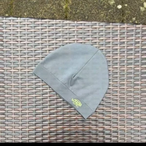 Grå mössa med märket Syna world - Snygg grå mössa med diskret broderad logga i gult framtill. Enkel och stilren design som passar perfekt till vardags. Tillverkad i mjukt material för skön passform. Säljer den eftersom den inte passat min huvudform och vid snabb äffar sänks priset