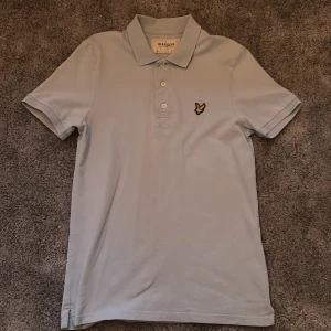 Ljusblå pikétröja från Lyle & Scott - Säljer en stilren ljusblå pikétröja från Lyle & Scott. Tröjan är i mycket bra skick och har inga defekter eller hål. Tröjan är i storlek xs.