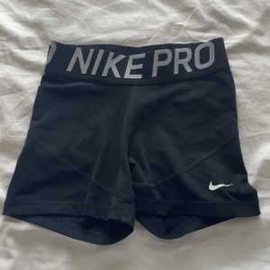 Svarta Nike Pro shorts - Svarta Nike Pro shorts med bred resår i midjan och logga framtill. Tight och kort passform