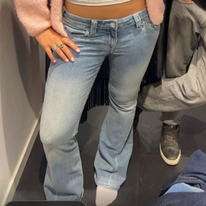 Ljusblå bootcut jeansbyxor från True Religion - Säljer ett par ljusblå jeansbyxor från True Religion med bootcut passform. Byxorna har klassiska fem fickor, snygga sömmar och logga på bakfickan. Perfekta för dig som gillar en retro vibe och vill ha ett par jeans som sticker ut.