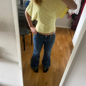 Blå jeansbyxor från Diesel - Säljer ett par klassiska blå jeans från Diesel med låg midja och bootcut-stil. Jeansen har fem fickor, synliga nitar och Diesel-logga på fickan. Perfekta för dig som gillar en avslappnad och tidlös look.