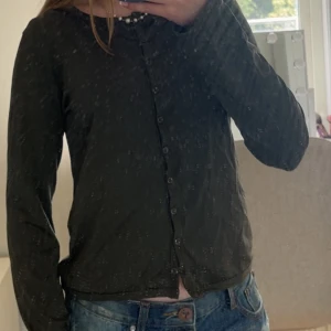 Mörkgrön kofta från Newhouse - Säljer en mörkgrön kofta från Newhouse med rund halsringning och knappar hela vägen framtill. Tröjan har långa ärmar och är i ett mjukt, tunt material som passar perfekt till sommaren. Jag skulle säga att tröjan är storlek XS-S.
