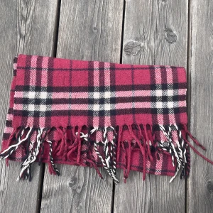 Vinröd burberry halsduk - Burberry halsduk i fint skick, någon skrapa och en liten fläck vilket syns på bild den är även tvättad men fortfarande någorlunda mjuk inte som den ska vara dock