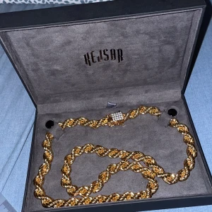 Guldfärgat 18k kedjehalsband från Kejsar - Säljer ett chunky guldfärgat halsband från Kejsar med tvinnad kedja och lås dekorerat med små gnistrande stenar. Perfekt statement piece för dig som gillar att sticka ut. Levereras i originalask.