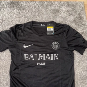 Balmain Psg Tröja - Säljer oanvänd med pristagg Svart balmain Psg t shirt. Storlek S och passar även M