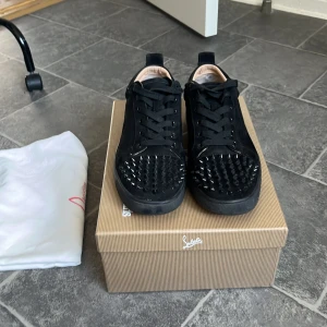 Svarta sneakers med nitar från Christian Louboutin - Säljer använda loubs storlek 42 svarta 