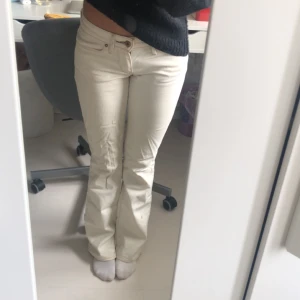 Lågmidjade Bootcut Jeans - Säljer ett par krämvita lågmidjade bootcut jeans från Levi’s i strl. 24. Defekter på sista bilden där det är lite slitage vid hälarna samt en del fläckar.