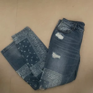  Jeans med print och slitningar - Blå jeans med paisleymönster och slitna detaljer framtill. Jeansen är väldigt unika med normal passform. Aldrig använda 💕