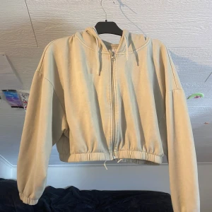 Mint grön croppad hoodiejacka från 157 - Säljer en mint grön croppad hoodiejacka från 157 i mjukt bomullsmaterial. Jackan har dragkedja framtill, huva med snörning och resår i midjan samt ärmslut. Perfekt för en avslappnad och trendig look. Har blecka fläckar på ryggen men märks inte så tydligt