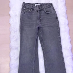 Grå jeans från Gina Tricot Perfect Jeans - Säljer ett par grå jeans från Gina Tricot, modellen Perfect Jeans. Byxorna har klassisk femficksdesign, raka ben och hög midja. Perfekta till en avslappnad stil och passar till många olika outfits. Finns liten blå fläck inne i byxan längst ner men inget som syns