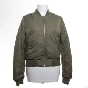 Olivgrön bomberjacka från Rut&Circle - Säljer en olivgrön bomberjacka från Rut&Circle. Jackan har dragkedja framtill, ribbade muddar vid ärmslut och midja samt klassisk bomberkrage. Köpte för några dagar sedan men den passade ej