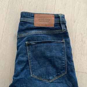 Blå jeans från Jack & Jones w30 L32 - Säljer ett par klassiska blå jeans från Jack & Jones. Modellen heter Slim Glenn och har en slim passform med normal midja. Jeansen har fem fickor, dragkedja och knapp framtill samt snygga kontrastsömmar.