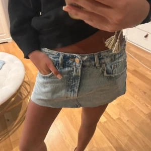 Ljusblå jeanskjol från trafaluc  - Superkort ljusblå jeanskjol från trafaluc med råa kanter och klassiska femficksdetaljer. Kjolen har bälteshällor och knappgylf, perfekt för en trendig och avslappnad look. ❣️förra ägarens bilder❣️ jag har inga på själv för passar inte mig🥰