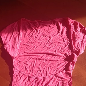 Rosa topp - Säljer en snygg rosa topp som är öppen i ryggen,Perfekt för varma dagar eller som ett lager under en jacka. Toppen har en enkel och stilren design.