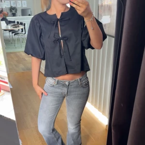 Svart puffärmad blus - Säljer en såå snygg svart blus med puffärmar och knytningar framtill. Knappt använd!!