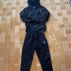 Svart tracksuit från Ralph Lauren - Säljer en svart tracksuit från Ralph Lauren. För mer bilder skicka dm. Svarar så snabbt ja kan. Kan gå ner i pris vid snabb köp. Den är helt ny aldrig använt.