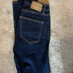 Mörkblå Levi's 501 jeans - Klassiska mörkblå Levi's 501 jeans med raka ben och snygga kontrastsömmar. Jeansen har fem fickor, knappgylf och är tillverkade i robust denim. Perfekta för dig som gillar tidlös stil och vill ha ett par jeans som funkar till allt.