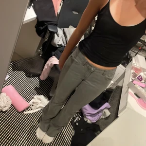 Grå bootcut jeans med låg midja - Säljer ett par gråa jeans med bootcut-modell och låg midja. Byxorna har klassisk femficksdesign och är i ett mjukt jeanstyg som sitter snyggt på benen. Perfekta om du gillar en clean och enkel stil med lite 00-talsvibe.